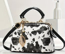 A black and white cow print purse