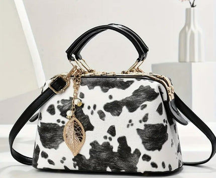 A black and white cow print purse