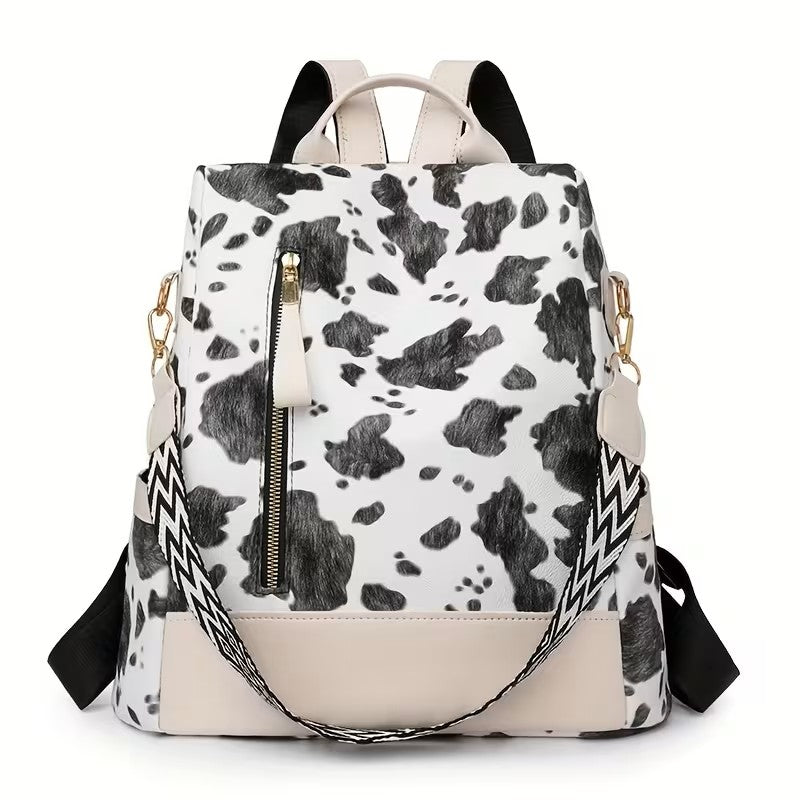 A black and white cow print backpack