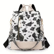 A black and white cow print backpack