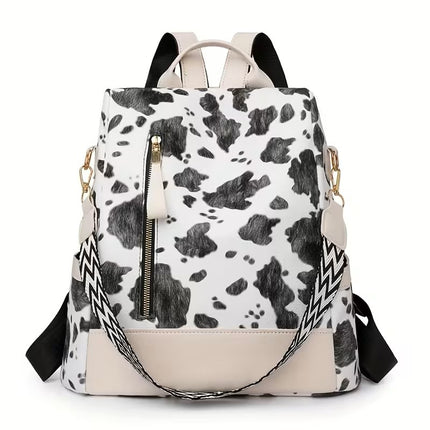A black and white cow print backpack
