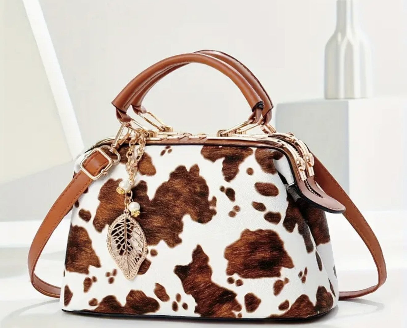 A brown and white cow print purse