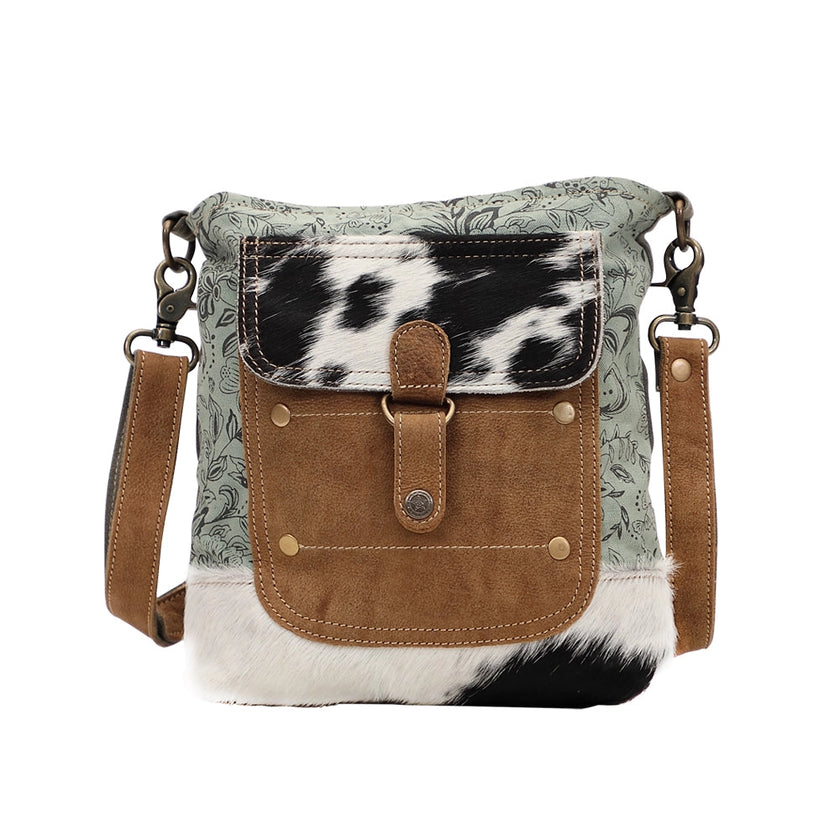 Crossbody bag with cowhide leather accents on a white background