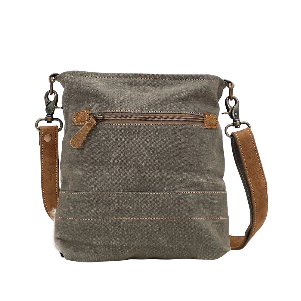 Brown leather crossbody bag with a strap on a white background