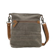 Brown leather crossbody bag with a strap on a white background