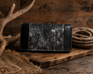 Black and gray leather wallet with intricate design on a wooden surface with rustic background