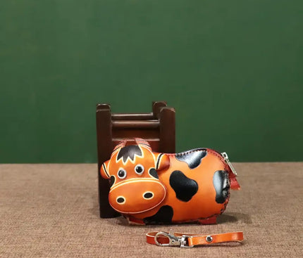 An orange cow coin purse shaped in a profile view
