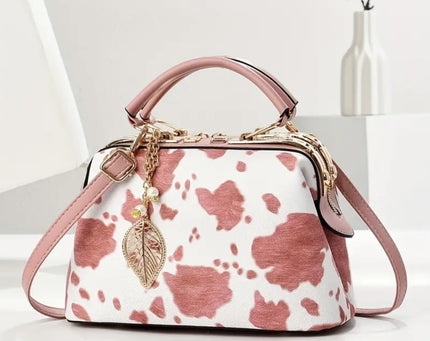 A pink and white cow print purse