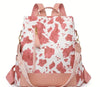 A pink and white cow print backpack